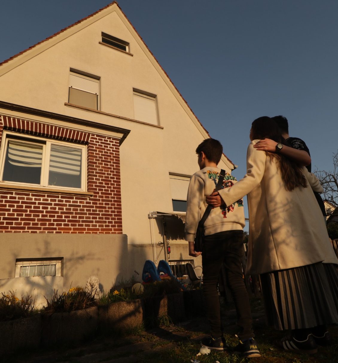 Zukunft für junge Familien in der Gemeinde Eine junge Familie steht vor einem Haus und blickt auf das Gebäude