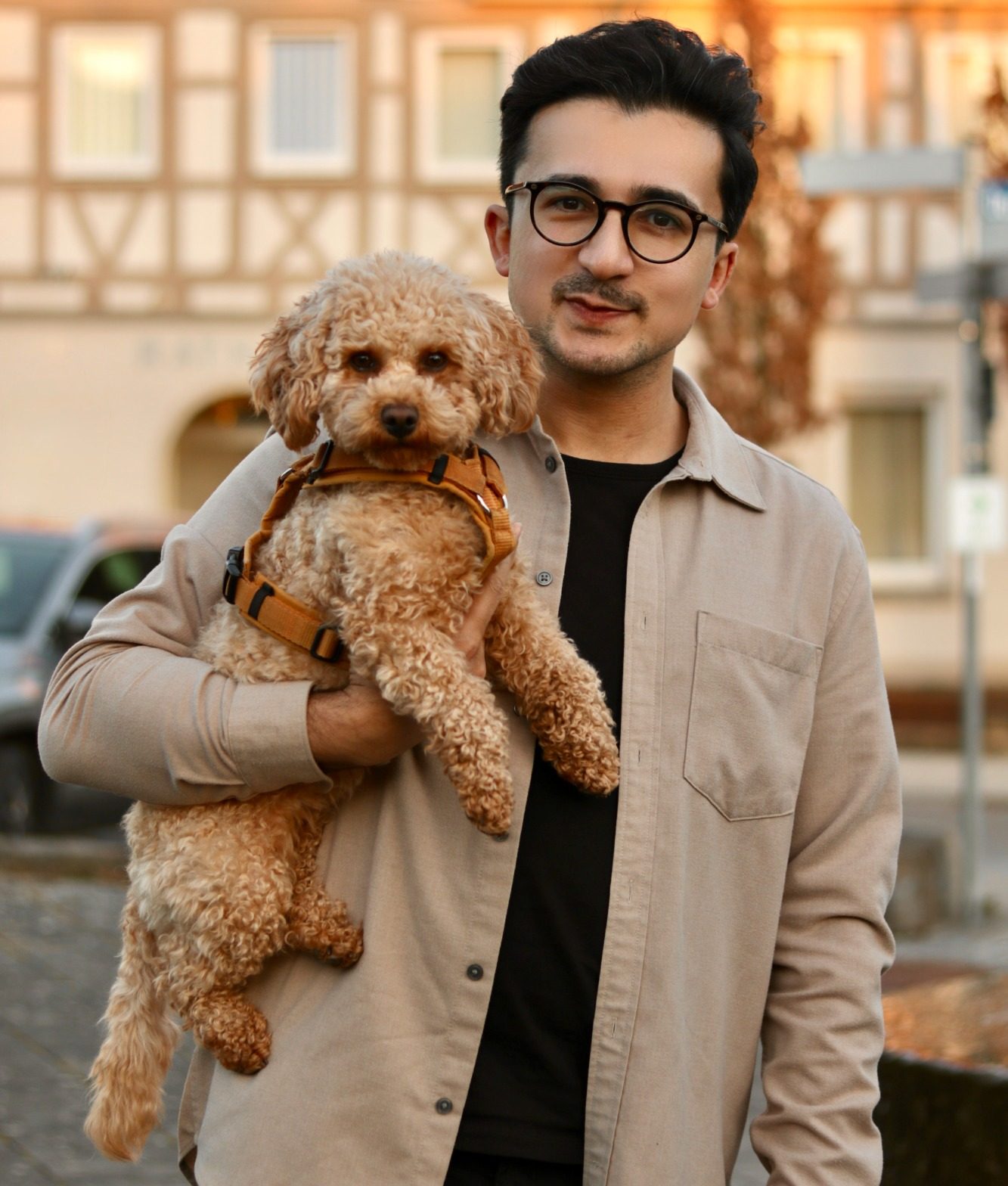 Unterwegs in unserer Gemeinde mit treuem Begleiter Porträt von Eser Turgut mit einem Zwergpudel unter seinem Arm