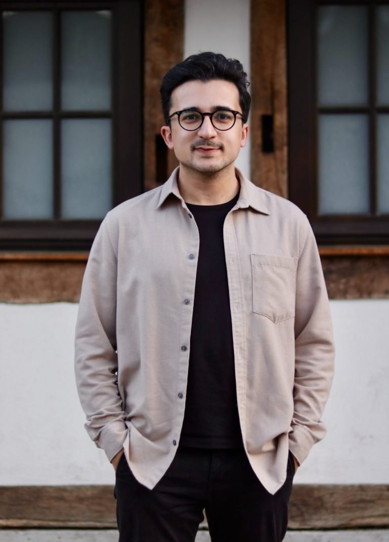 Ihr Bürgermeisterkandidat für Kusterdingen Porträt von Eser Turgut vor einer Wand mit Fenstern